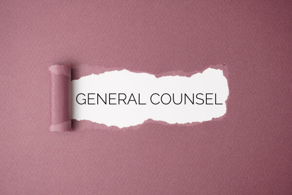 Aufgerissenes Papier gibt den Schriftzug &bdquo;General Counsel&ldquo; frei