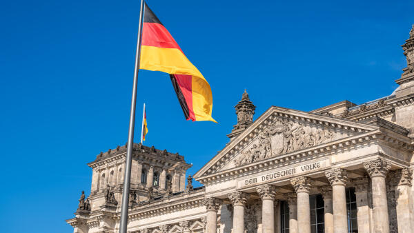 Deutsche Flagge vor dem Reichstagsgeb&auml;ude in Berlin