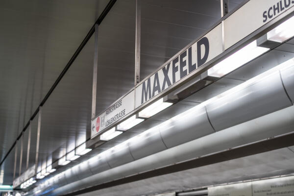 Bahnsteig der N&uuml;rnberger U-Bahn-Station Maxfeld mit beleuchtetem Stationsschild
