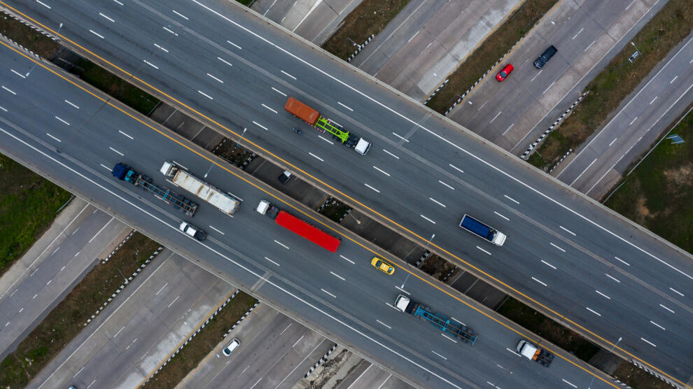 Luftaufnahme eines Autobahnkreuzes mit Lkw und Pkw auf sich kreuzenden Fahrbahnen