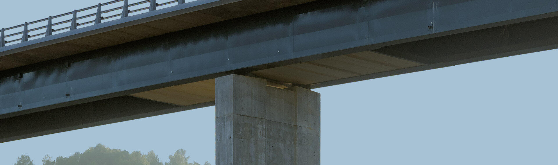 Betonpfeiler und Fahrbahn eines Autobahnviadukts &uuml;ber bewaldeten H&uuml;geln