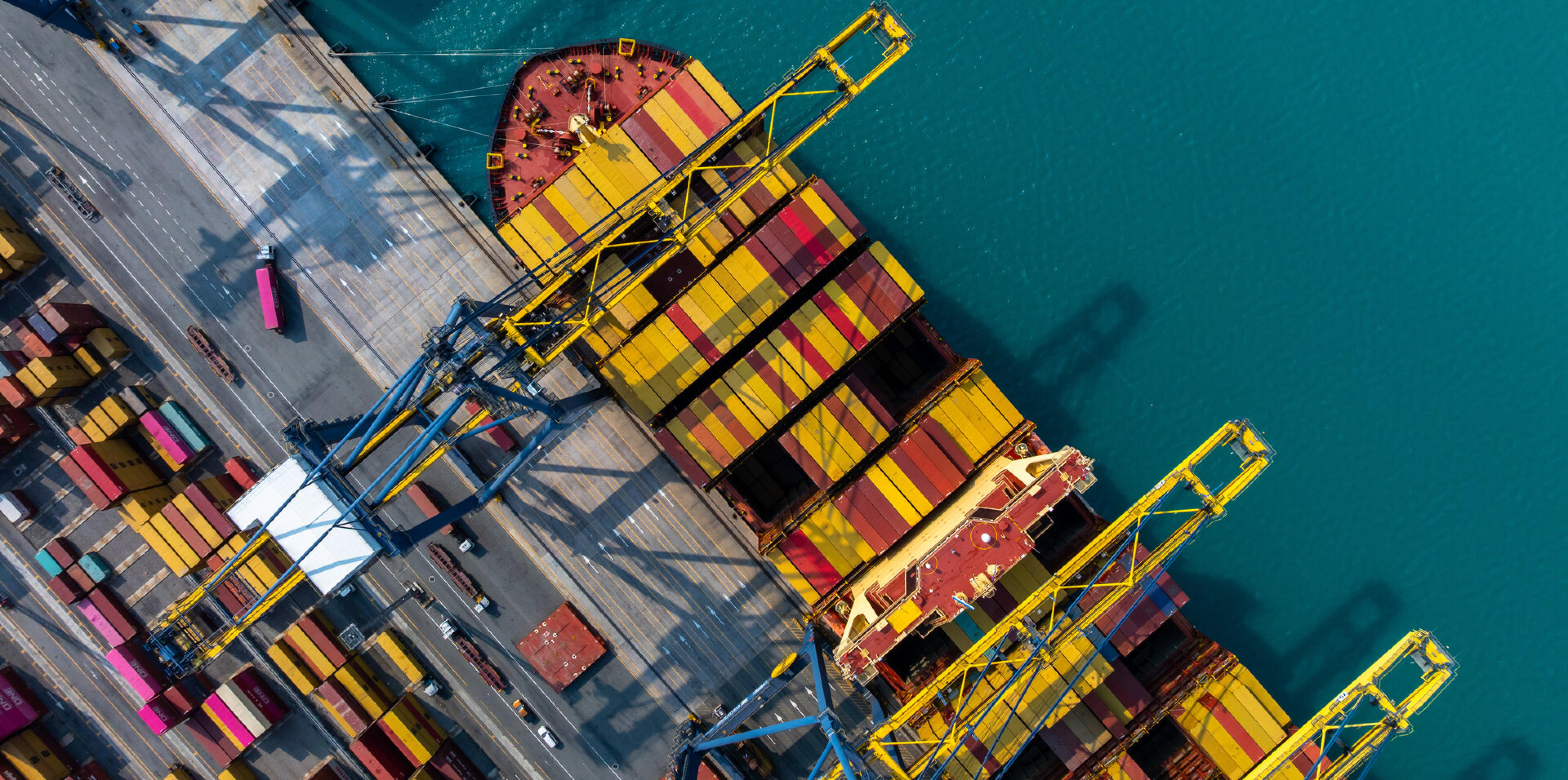 Luftaufnahme eines Containerschiffs beim L&ouml;schen der Ladung im Hafen