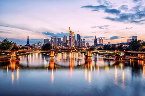 Frankfurter Skyline mit Ignatz-Bubis-Br&uuml;cke &uuml;ber dem Main in der Abendd&auml;mmerung