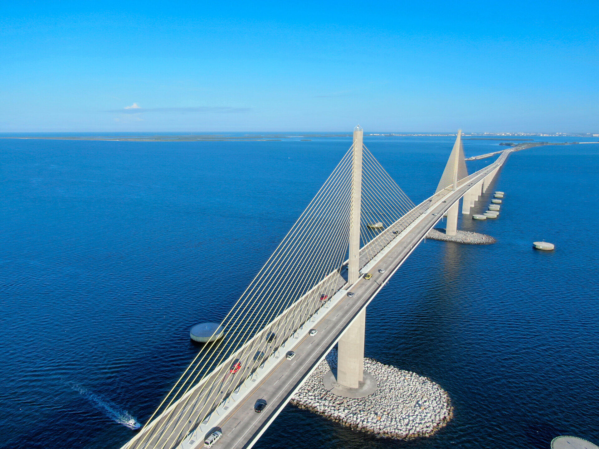 Luftaufnahme einer Schr&auml;gseilbr&uuml;cke &uuml;ber t&uuml;rkisfarbenem Wasser
