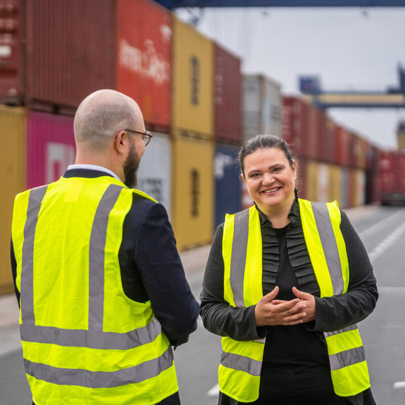 Stela Ivanova im Gespr&auml;ch mit einem Kollegen in Warnwesten an einem Containerterminal