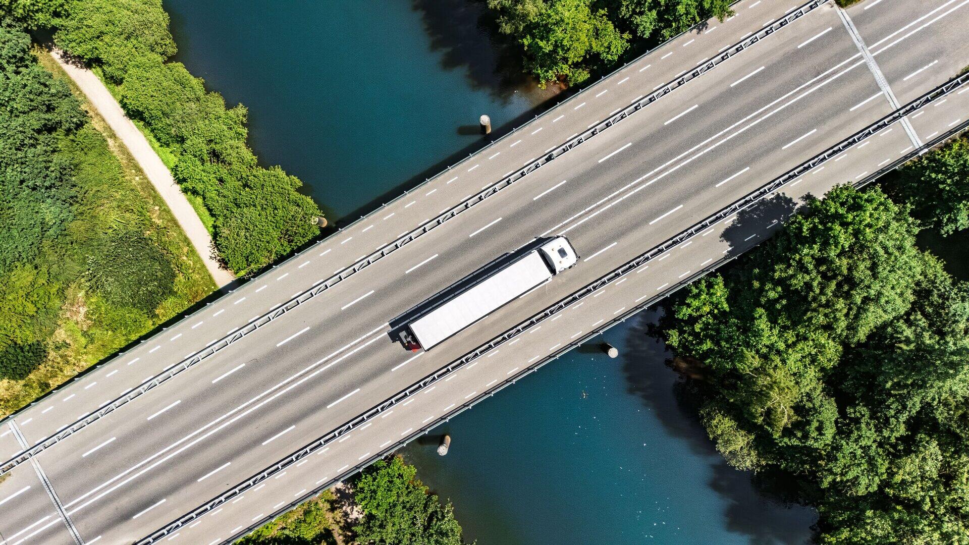Luftaufnahme eines Lkw auf einer Autobahnbr&uuml;cke &uuml;ber einem Fluss