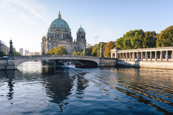 Berliner Dom an der Spree mit Br&uuml;cke, Ausflugsboot und Kolonnaden im Morgenlicht