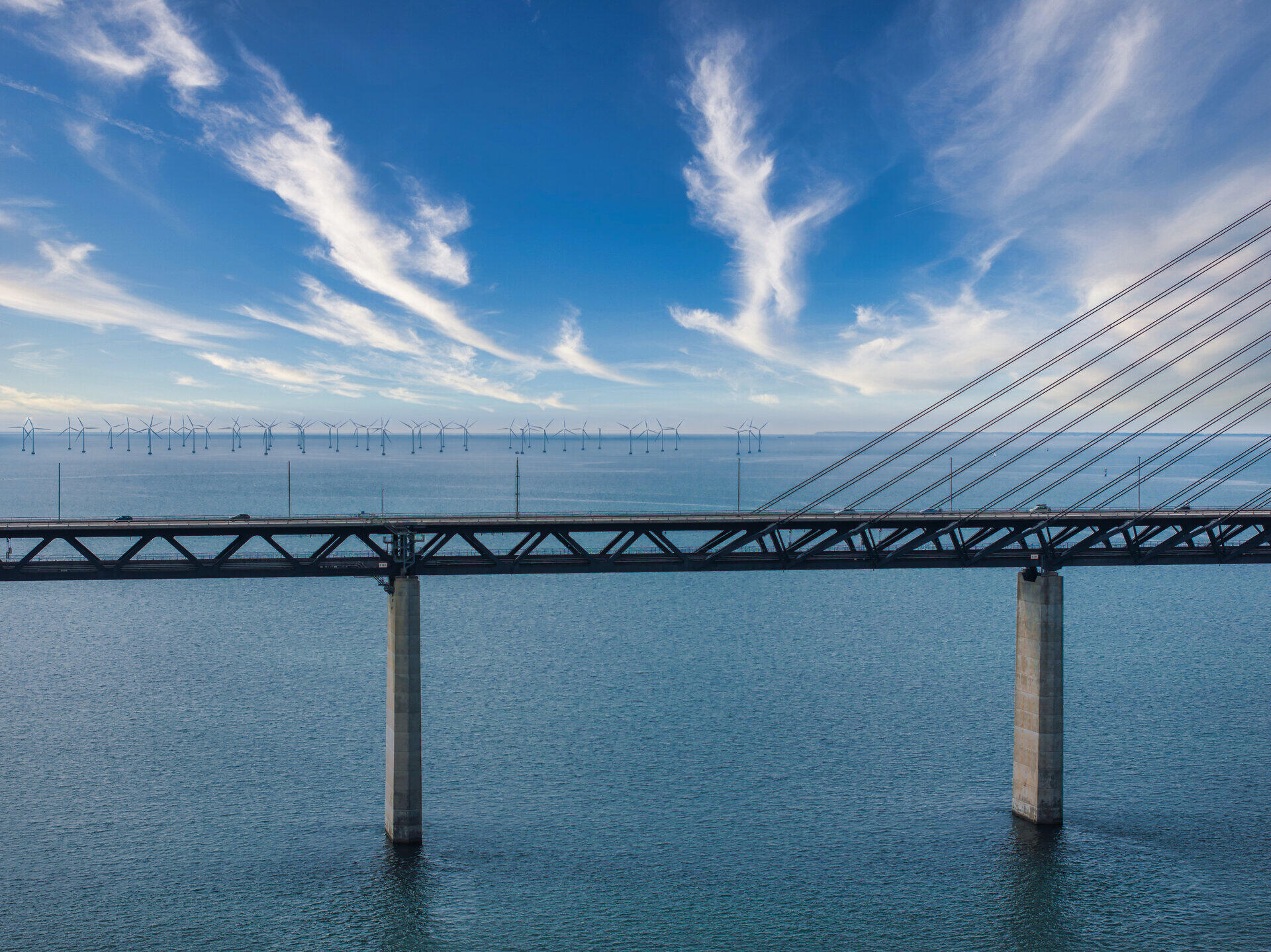 &Ouml;resundbr&uuml;cke &uuml;ber dem Meer, im Hintergrund Windr&auml;der eines Offshore-Windparks