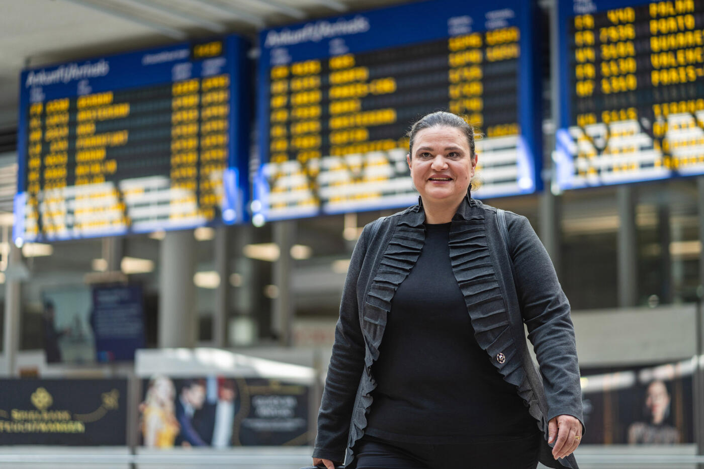 Portr&auml;t: Stela Ivanova vor Anzeigetafeln in einer Bahnhofshalle