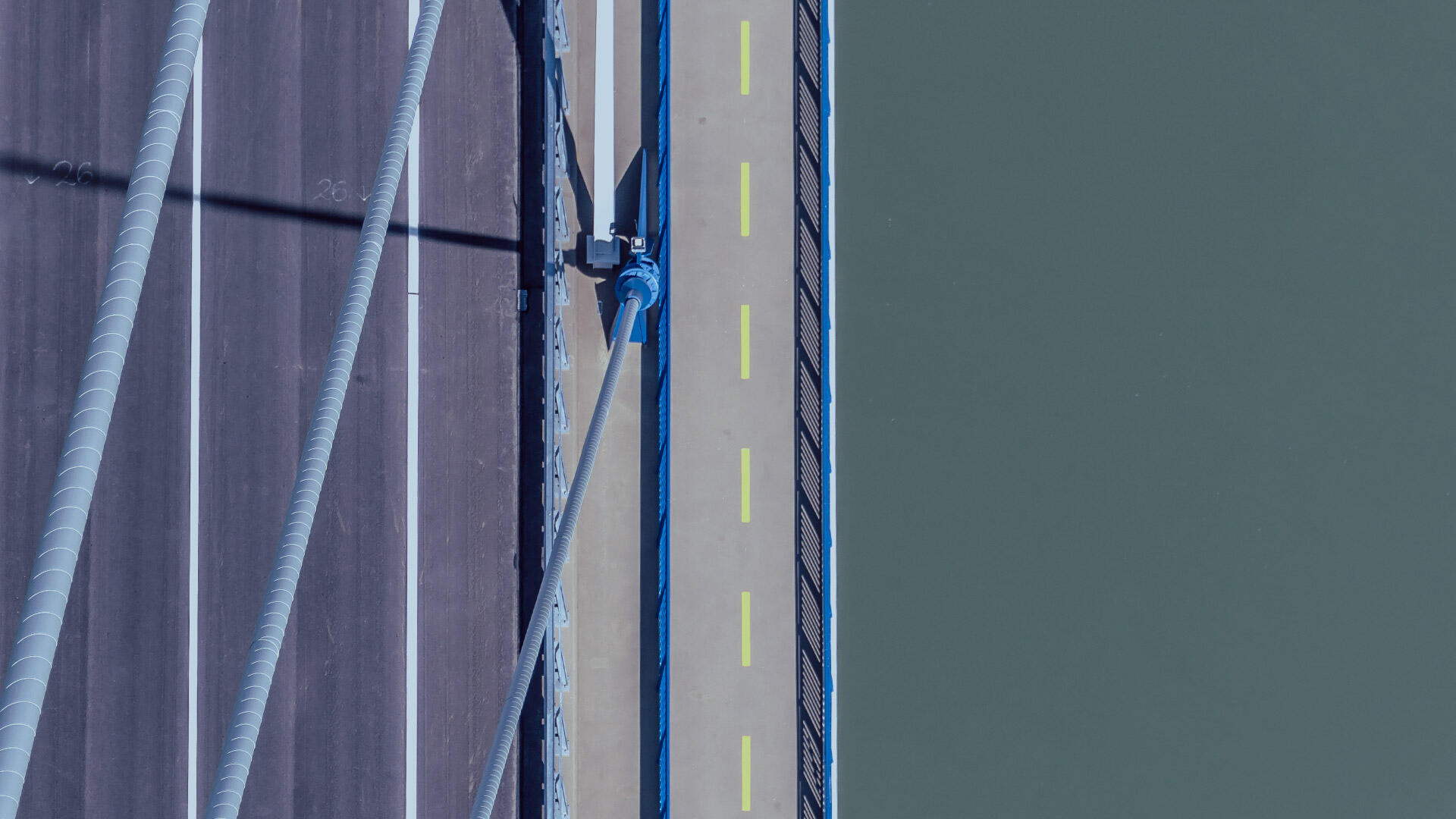 H&auml;ngebr&uuml;cke von oben: Fahrbahn mit Tragseilen &uuml;ber dem Wasser
