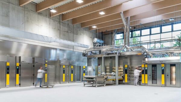 Backofenhalle von MIWE mit Edelstahl-&Ouml;fen und Mitarbeiter mit Stikkenwagen